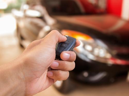 A locksmith in San Antonio, TX checking that a new key fob is working to open a vehicle. Our automotive locksmiths don't just open your car, they can replace car keys.